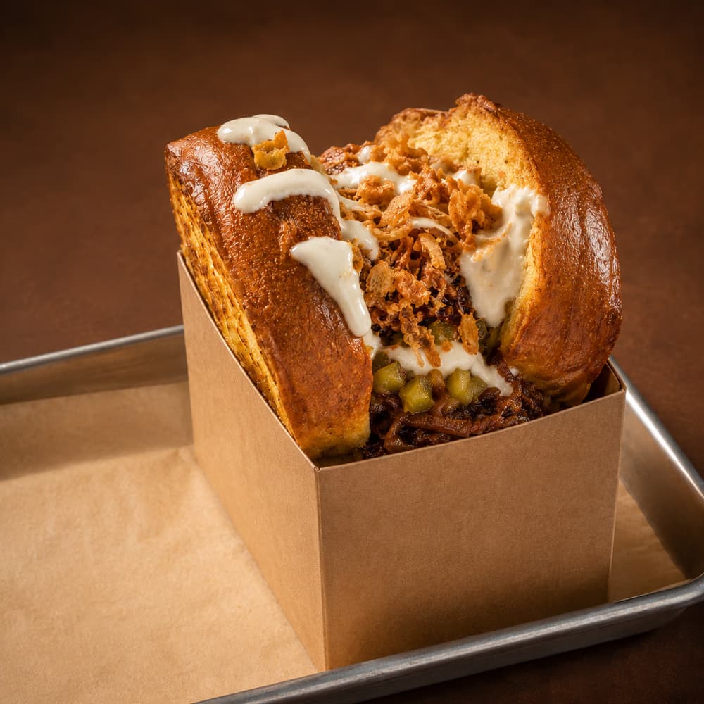 Brioche Texas de BRIOXX con pulled pork barbacoa, cheddar ahumado, relish de pepinillo, salsa ranch y cebolla crujiente